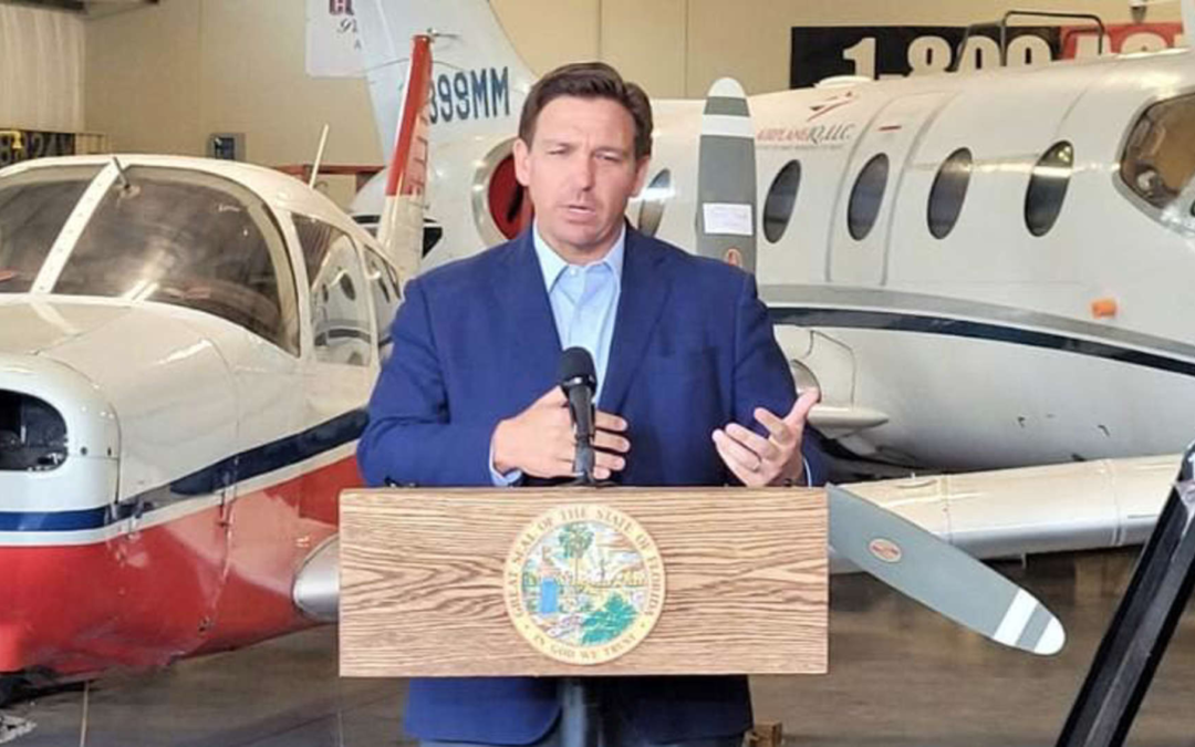 DeSantis standing in front of planes.